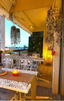 a restaurant with tables and chairs on a patio at Les Floralies - Beaulieu-sur-Mer in Beaulieu-sur-Mer