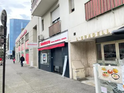 a man walking down a street in front of a store at STUDIO EN FACE DE LA PLAGE AVEC une VUE FANTASTIQUE ! in Nice