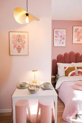 a pink bedroom with a bed and a table and stools at Casa Luna in Nice