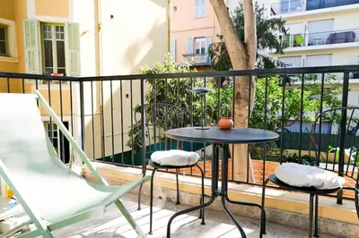 a table and chairs on a balcony with a tree at Casa Luna in Nice