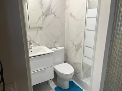 a white bathroom with a toilet and a sink at Nice Cosy in Nice