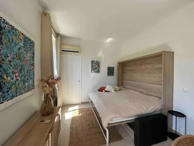 a bedroom with a bed with a wooden headboard at Beautiful studio with parking place Massena in Nice