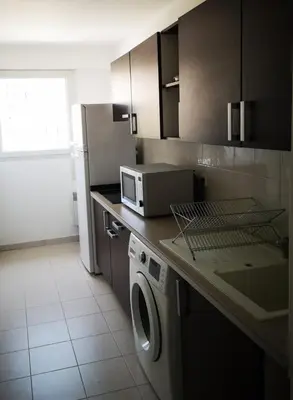 a kitchen with a washing machine and a microwave at Appartement cosy sur la French Riviera I Climatisation I 2 minutes des plages in Nice