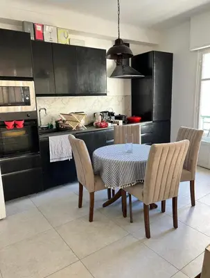 a kitchen with a table and chairs in a kitchen at Shared flat in Liberation in Nice
