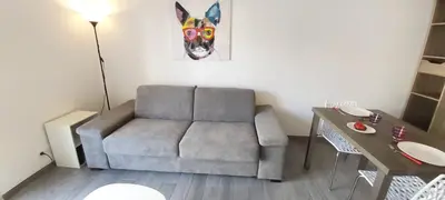 a living room with a couch and a table at Studio Cosy proche Carlone, balcon in Nice