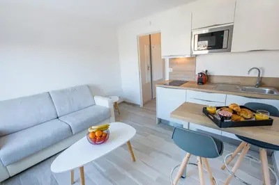 a living room with a couch and a table with a tray of fruit at Joli Studio proche Promenade des Anglais in Nice