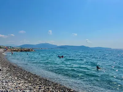 a group of people in the water at a beach at Studio élégant avec balcon près de la plage à Nice in Nice