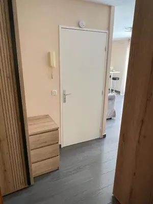 a room with a door and a table and a chair at Studio élégant avec balcon près de la plage à Nice in Nice