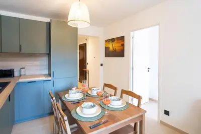 a kitchen and dining room with a wooden table with chairs at #41 Flat for 6, 3 Bdrs Parking Wifi 5mins walk Tram T1 in Nice