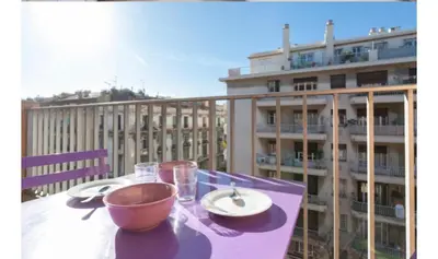 a table with a bowl and plates and glasses on a balcony at Studio Nice clim wifi in Nice