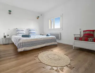 a bedroom with a large bed and a rug at Appartement spacieux & vue imprenable in Saint-Laurent-du-Var