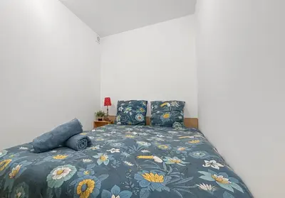 a bedroom with a bed with a blue floral bedspread at Appartement spacieux & vue imprenable in Saint-Laurent-du-Var