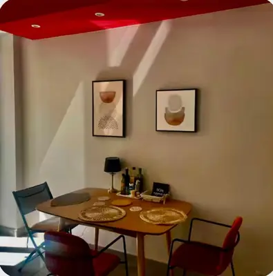 a dining room table with chairs and a red ceiling at Suite Massena in Nice