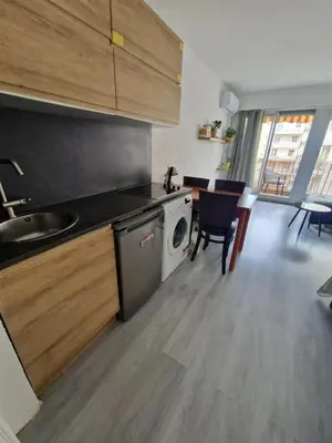 a kitchen with a washing machine and a table with chairs at Lory's home in Nice