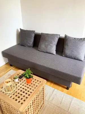 a living room with a blue couch and a tv at Studio balcon proche mer in Nice