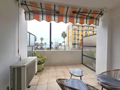 a balcony with chairs and a window with a view of a city at Large T2 50m from the beaches in Nice