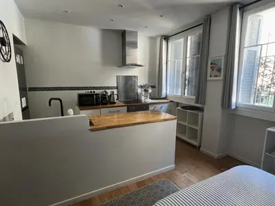 a kitchen with a counter top and some windows at Coquette studio YourHostelper in Nice