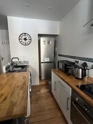a kitchen with a counter and a refrigerator and a clock at Coquette studio YourHostelper in Nice