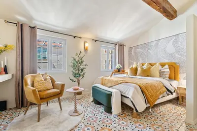 a bedroom with a king sized bed and a chair at Nice Renting - CENTRALE - Authentic Loft Old Nice Rooftop View & Charm in Nice