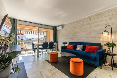 a living room with a blue couch and a table at Jolie studio avec belle terrasse ensoleillee in Nice