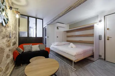 a bedroom with a bed and a couch and a table at Coquet studio place du pin in Nice