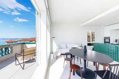 a room with a balcony with a table and chairs at New - sea view - splendid apartment in Nice
