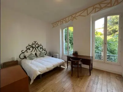 a bedroom with a bed and a desk and a window at Villa Adelaida in Nice