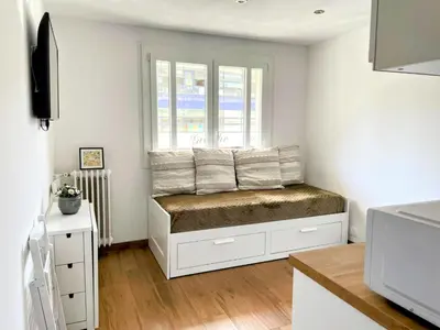 a room with a window and a bench with pillows at Modern apartment, steps from tramway in Nice