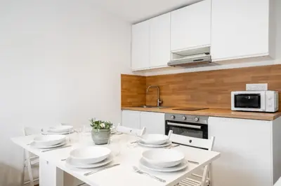 a kitchen with a table with white dishes on it at Modern apartment, steps from tramway in Nice