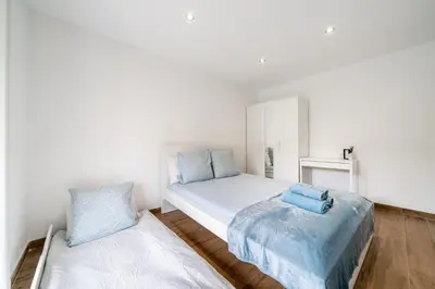 a white bedroom with a bed and a pillow at Modern apartment, steps from tramway in Nice