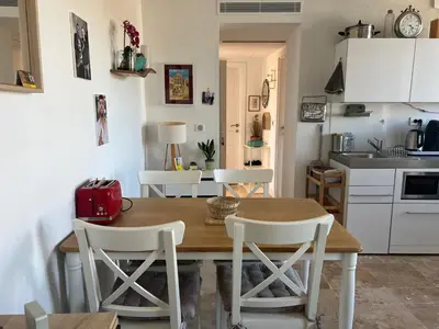 a kitchen and dining room with a wooden table and chairs at appartement maison de village in Cagnes-sur-Mer