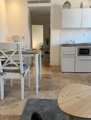 a kitchen with a table and a white table and chairs at appartement maison de village in Cagnes-sur-Mer