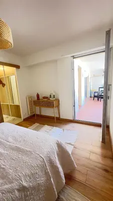 a bedroom with a bed and a view of a patio at Grand 2 pièces avec grande terrasse à 15mn Centre-ville, Gare et Promenade des Anglais in Nice