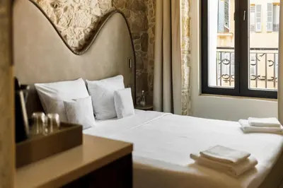 a bedroom with a white bed with a window at Notre Dame Hotel - Self Check-in in Nice