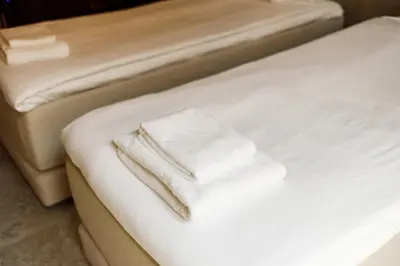 two white towels are stacked on a bed at Notre Dame Hotel - Self Check-in in Nice