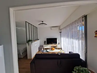 a living room with a blue couch and a large window at Chez Stella - Proche Mer in Nice