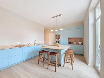 a kitchen with blue cabinets and a island with stools at Nestor&Jeeves - PEPYTE - Design - Near Beach in Nice