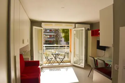 a living room with a red couch and an open door at Studio avec terrasse à Nice in Nice