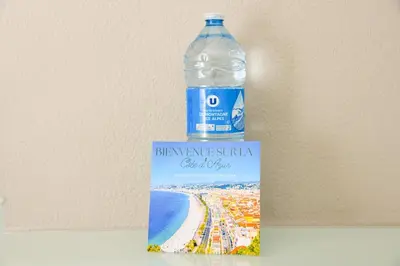 a bottle of water sitting on top of a book at Studio avec terrasse à Nice in Nice