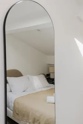 a mirror reflecting a bed with white sheets and pillows at Modern 3BR Duplex Near Nice Port & Old Town | By Airnest in Nice