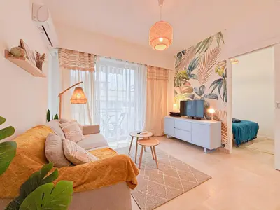 a living room with a couch and a television at Plage, Promenade & confort - Wifi, AC, 4 pers in Nice