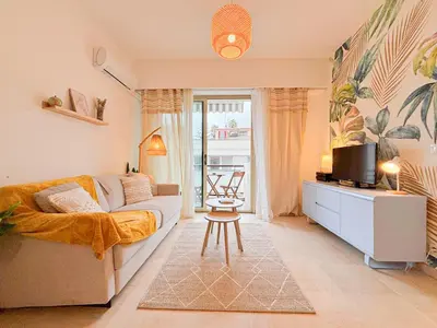 a living room with a couch and a tv at Plage, Promenade & confort - Wifi, AC, 4 pers in Nice