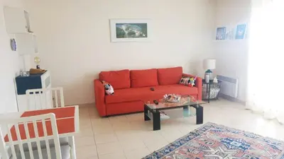 a living room with a red couch and a coffee table at Entire Condo in Nice in Nice