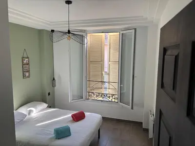 a bedroom with a white bed and a window at 3-R bright, beach within 15 min walk in Nice
