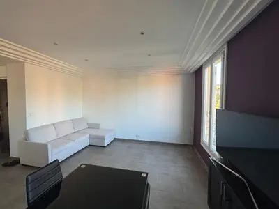 a living room with a white couch and a flat screen tv at 3-R bright, beach within 15 min walk in Nice