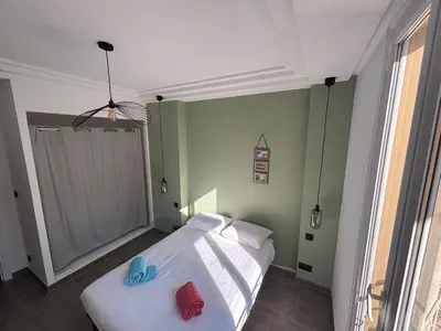 a bedroom with a bed with two blue slippers on it at 3-R bright, beach within 15 min walk in Nice