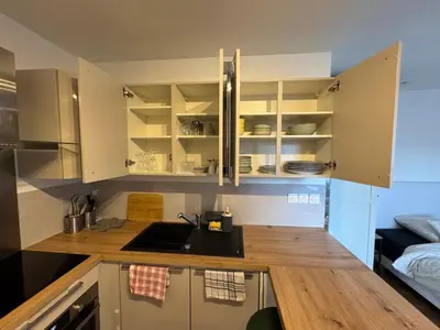 a kitchen with white cabinets and a sink at Beau Studio avec belle terrasse au centre ville de Nice in Nice