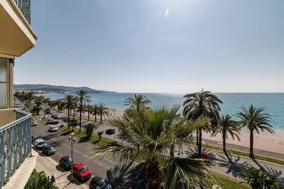 a view of a street with palm trees and the beach at Sea View - Lovely Studio Promenade des Anglais in Nice