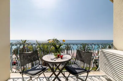 a table and chairs on a balcony with the ocean at Sea View - Lovely Studio Promenade des Anglais in Nice