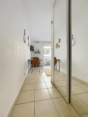 a hallway with a mirror and a table in a room at Studio calme avec balcon proche du port de Nice in Nice